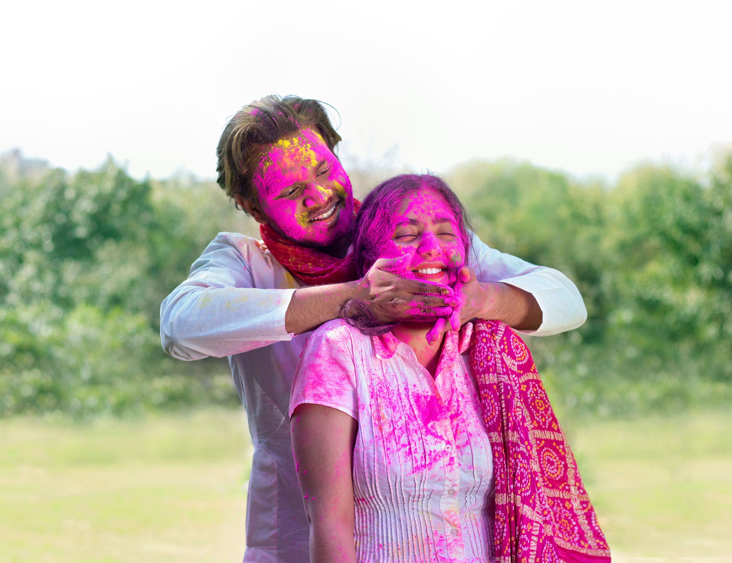 A man applying colours on a girls face from her behind